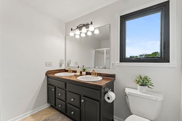 bathroom with an enclosed shower, vanity, toilet, and a wealth of natural light