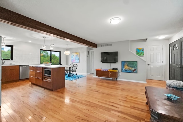 kitchen featuring light hardwood / wood-style floors, a kitchen island, stainless steel appliances, decorative light fixtures, and a chandelier