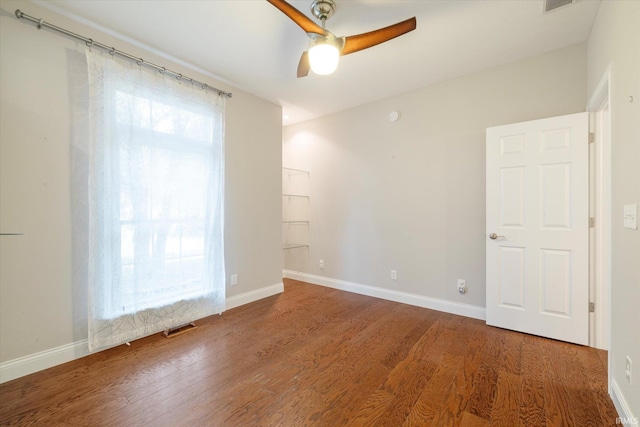 unfurnished room with visible vents, baseboards, a ceiling fan, and wood finished floors