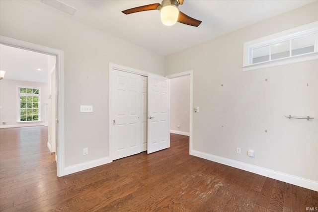 unfurnished bedroom with wood finished floors, ceiling fan, baseboards, and a closet