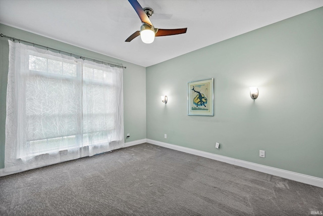 carpeted spare room with baseboards and a ceiling fan