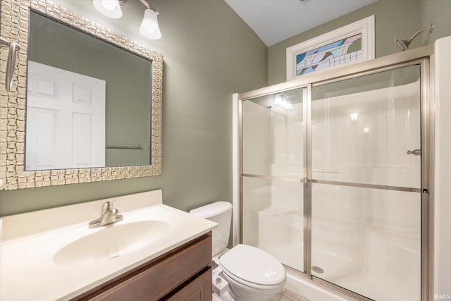 bathroom with toilet, a shower stall, and vanity