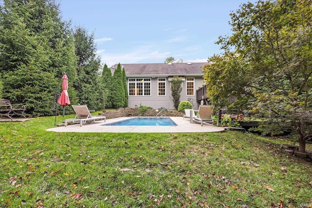 back of house featuring a patio, an outdoor pool, and a lawn