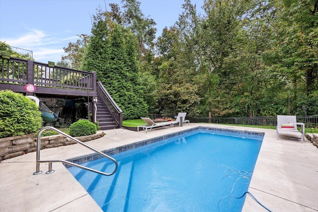 view of pool with a patio area, fence, stairs, a wooden deck, and a fenced in pool