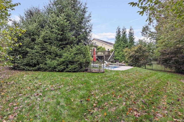 view of yard with a wooden deck, a patio area, and fence