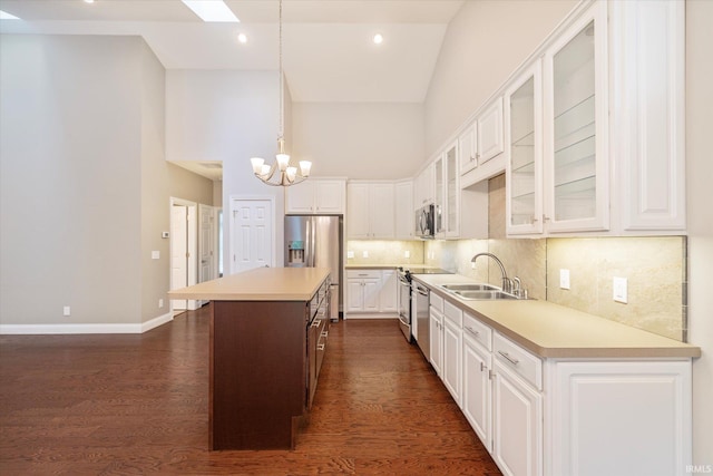 kitchen with light countertops, appliances with stainless steel finishes, a notable chandelier, and white cabinetry