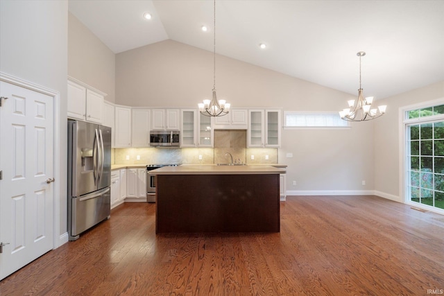 kitchen featuring appliances with stainless steel finishes, a sink, a notable chandelier, and dark wood finished floors