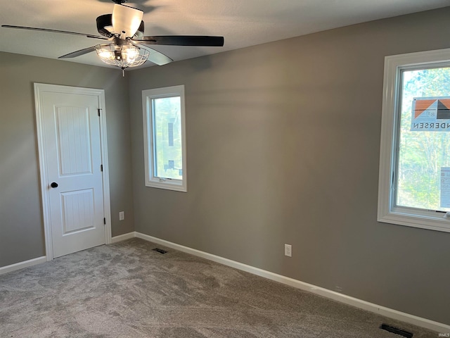 spare room featuring light carpet and ceiling fan