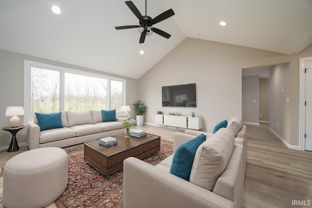 living room featuring ceiling fan, light wood-type flooring, and high vaulted ceiling