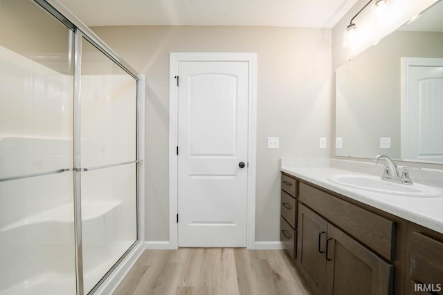 bathroom featuring hardwood / wood-style floors, vanity, and walk in shower