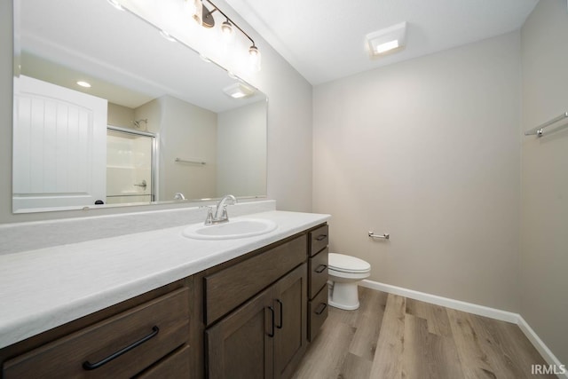 bathroom featuring hardwood / wood-style flooring, vanity, toilet, and walk in shower