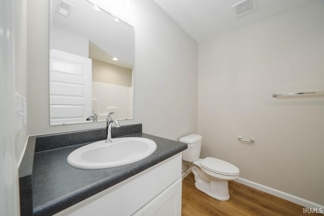 bathroom featuring vanity, hardwood / wood-style floors, and toilet