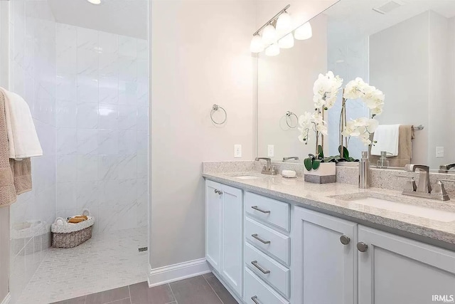 bathroom with a tile shower, tile patterned floors, and vanity