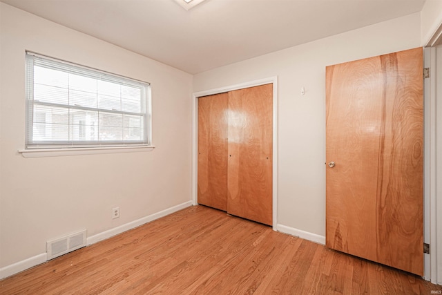 unfurnished bedroom featuring light hardwood / wood-style flooring and a closet