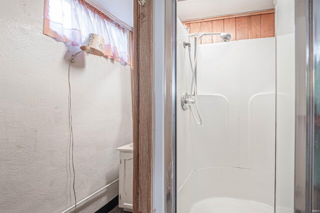 bathroom featuring a shower with shower door