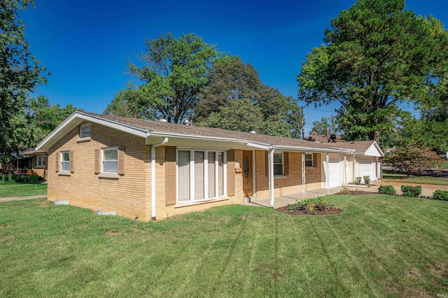 back of property featuring a lawn and a garage