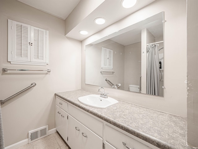 bathroom with curtained shower, vanity, toilet, and tile patterned floors