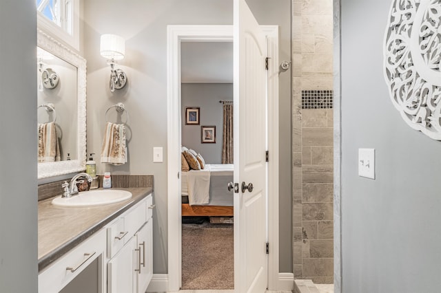 bathroom with a tile shower and vanity