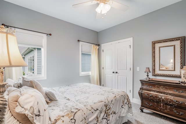 carpeted bedroom with ceiling fan and a closet