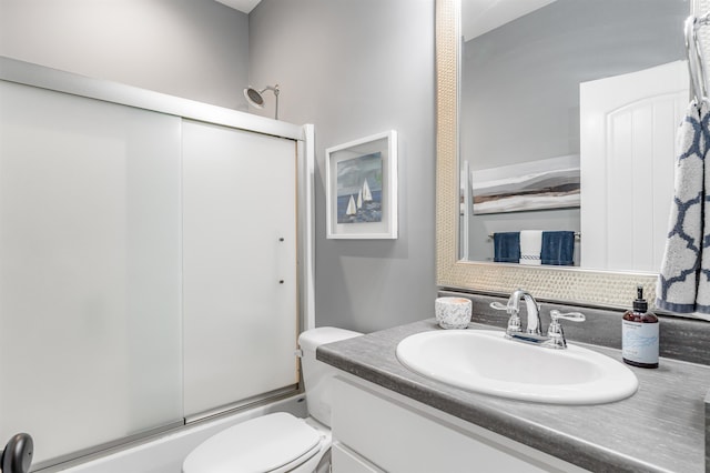 full bathroom with shower / bath combination with glass door, vanity, and toilet