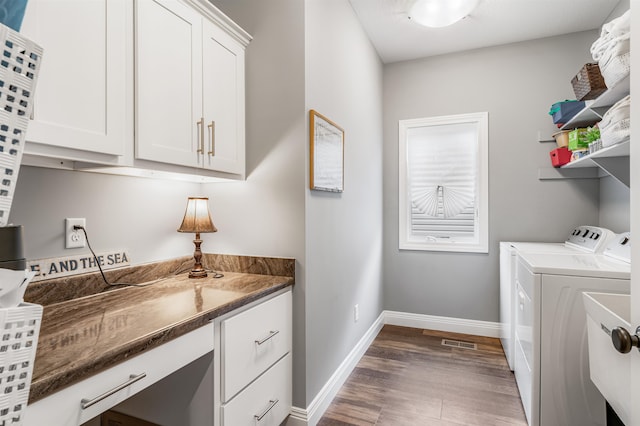 clothes washing area with dark hardwood / wood-style flooring, cabinets, and washing machine and dryer