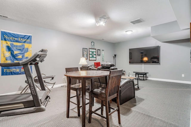 carpeted dining room with a textured ceiling