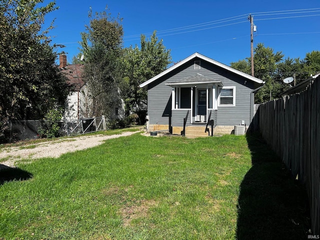 view of front of home featuring a front lawn and central AC