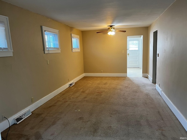 carpeted spare room featuring ceiling fan