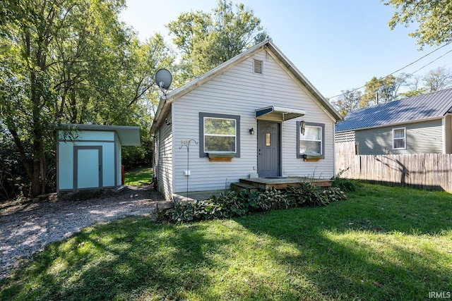 bungalow-style house featuring a storage shed and a front yard