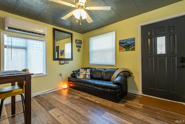 interior space featuring an AC wall unit, ceiling fan, and hardwood / wood-style flooring