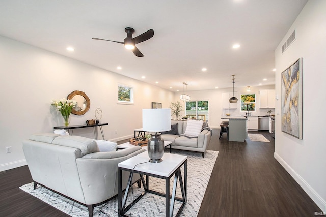 living room featuring ceiling fan and dark hardwood / wood-style flooring