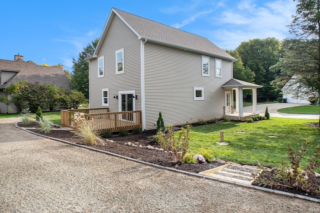 view of property exterior with a lawn, a garage, and a wooden deck