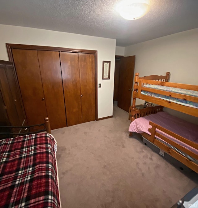 bedroom with light carpet, a textured ceiling, and a closet