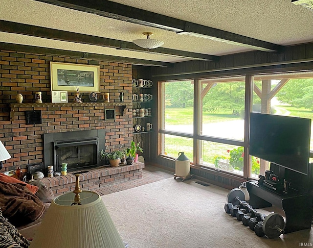 living room featuring carpet floors, a textured ceiling, and beamed ceiling