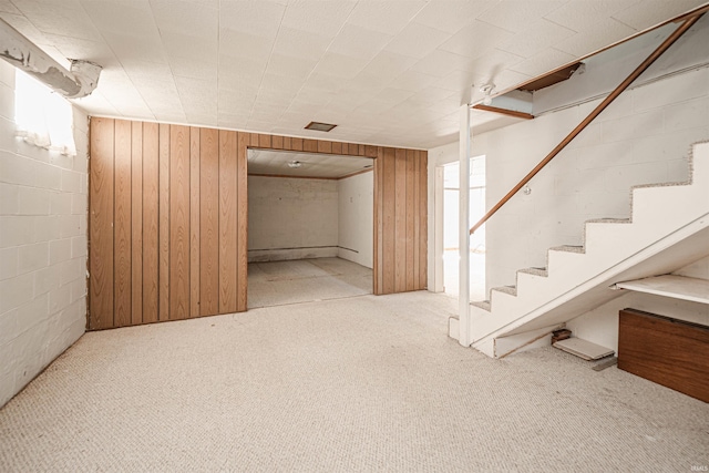 basement with wooden walls and light colored carpet