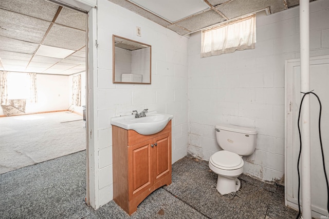 bathroom with a drop ceiling, vanity, and toilet