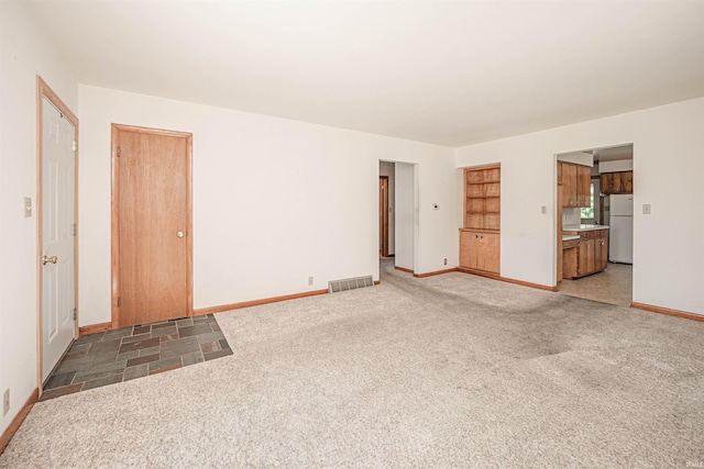 unfurnished living room featuring dark colored carpet