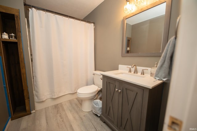 full bathroom with wood-type flooring, shower / tub combo with curtain, vanity, and toilet