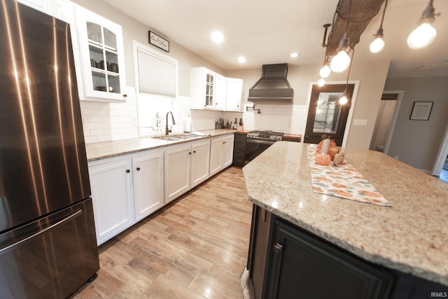 kitchen with appliances with stainless steel finishes, premium range hood, and white cabinets