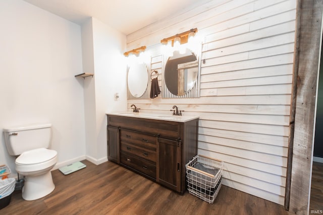 bathroom featuring wood-type flooring, vanity, and toilet