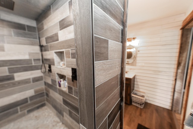 bathroom with wood walls and hardwood / wood-style floors