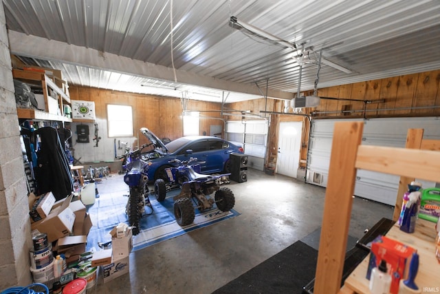 garage with a garage door opener and wood walls