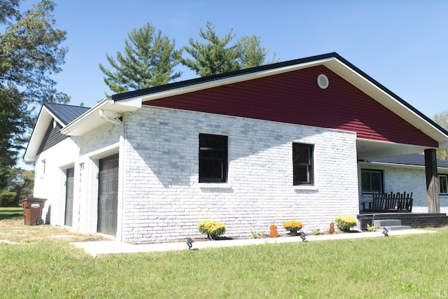 view of property exterior featuring a yard, a garage, and covered porch