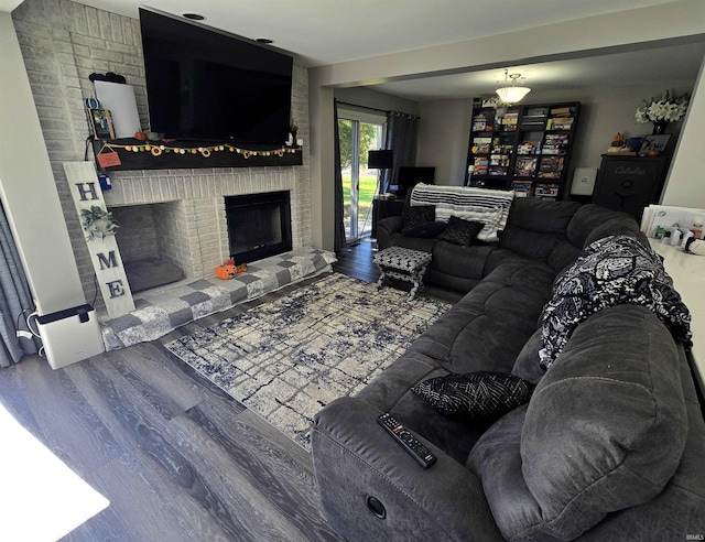 living room featuring hardwood / wood-style flooring and a brick fireplace