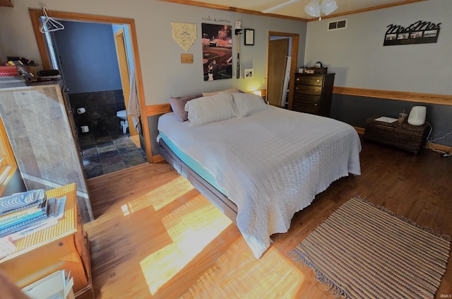 bedroom featuring hardwood / wood-style flooring, ceiling fan, and ornamental molding