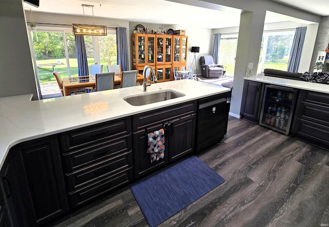 kitchen with light stone countertops, sink, hanging light fixtures, wine cooler, and dark hardwood / wood-style floors