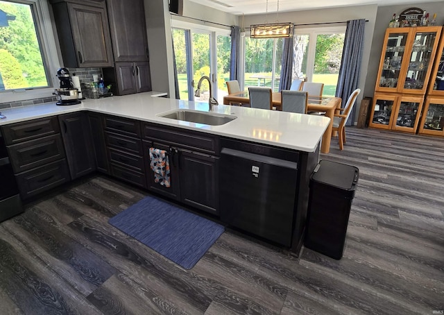 kitchen with pendant lighting, sink, tasteful backsplash, dark hardwood / wood-style flooring, and kitchen peninsula