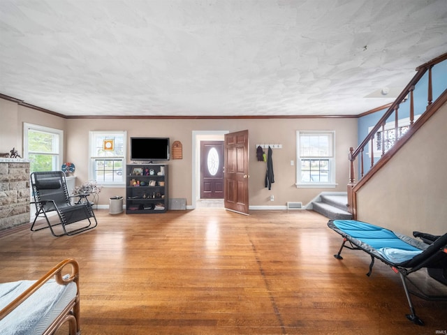 living room with light wood-type flooring and crown molding