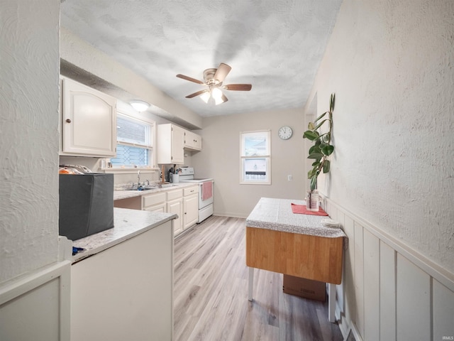 kitchen with ceiling fan, light hardwood / wood-style flooring, plenty of natural light, and white range with electric stovetop