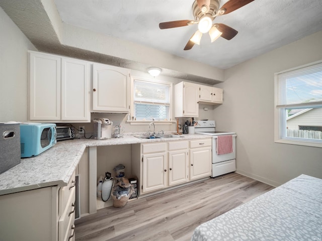 kitchen with white cabinets, white electric range oven, plenty of natural light, and sink